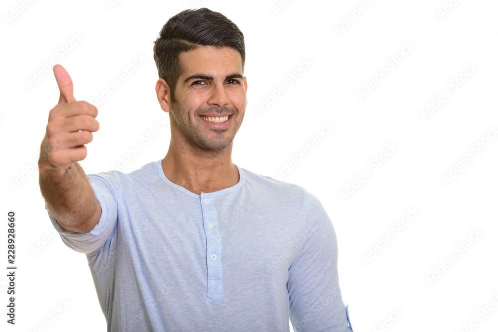 Young happy Persian man smiling and giving thumb up Young happy Persian man smiling and giving thumb up