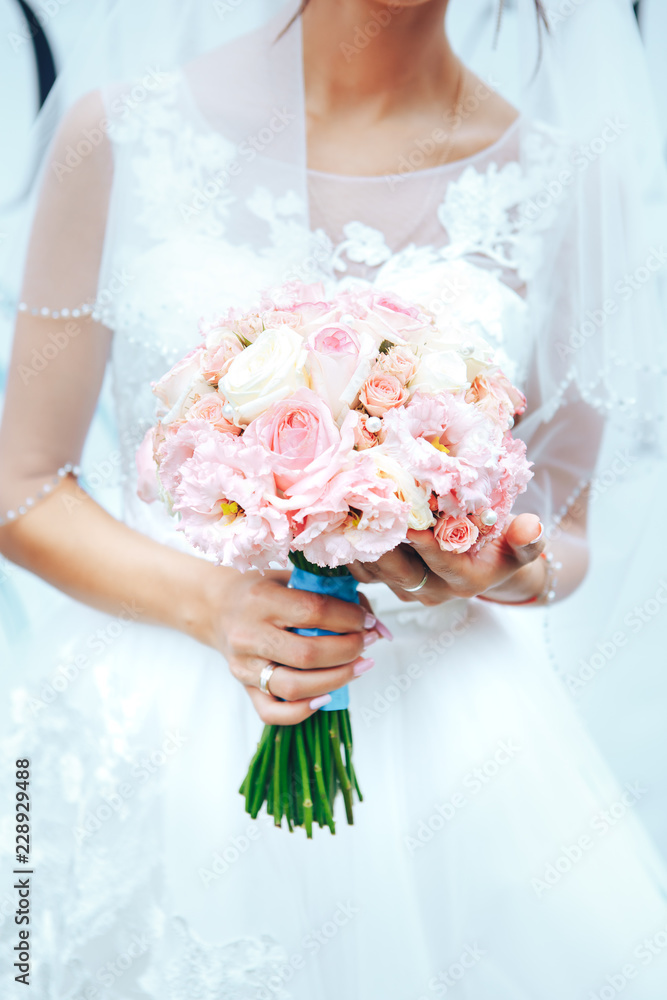 Bride holding a wedding bouquet in pastel pink colors. closeup Bride holding a wedding bouquet in pastel pink colors. closeup
