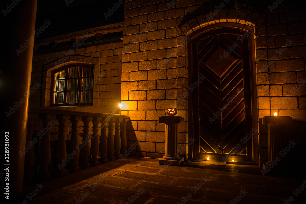 Front door to a house decorated with Halloween pumpkin. Halloween pumpkin on a door steep Front door to a house decorated with Halloween pumpkin. Halloween pumpkin on a door steep