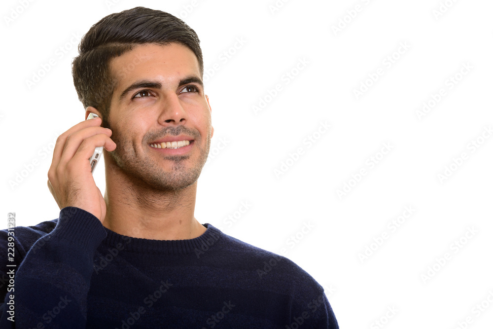 Young happy Persian man smiling and talking on mobile phone whil Young happy Persian man smiling and talking on mobile phone whil