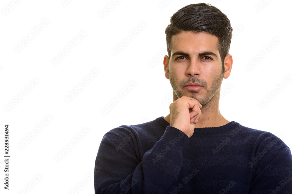 Thoughtful young handsome Persian man holding hand on chin Thoughtful young handsome Persian man holding hand on chin