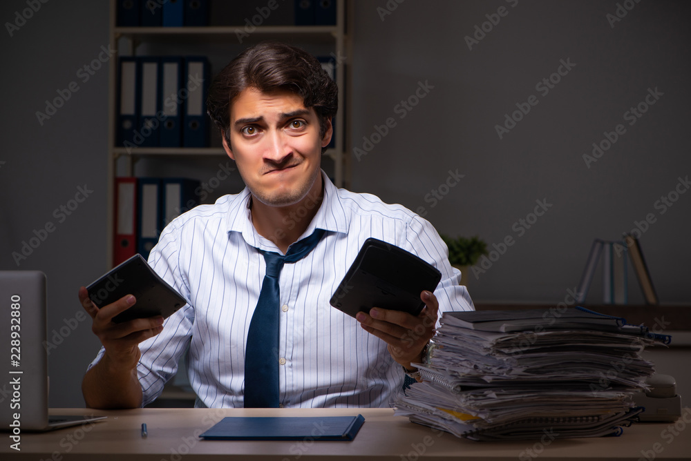 Young financial manager working late at night in office Young financial manager working late at night in office