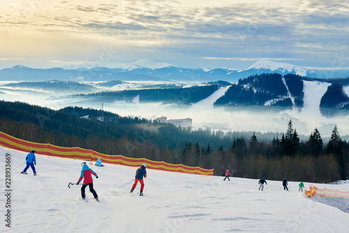 Skiers relaxing at carpathian mountains on sunny winter day