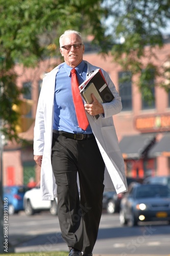 Smiling Handsome Senior Male Doctor Walking © dtiberio