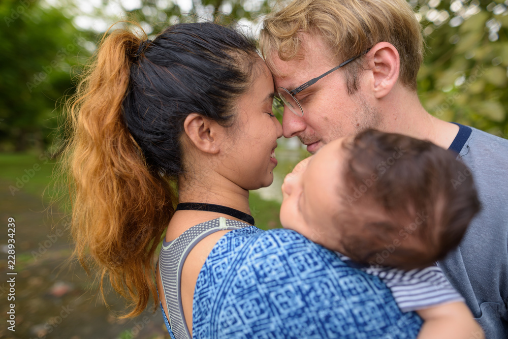 Multi-ethnic young family bonding together at the park Multi-ethnic young family bonding together at the park