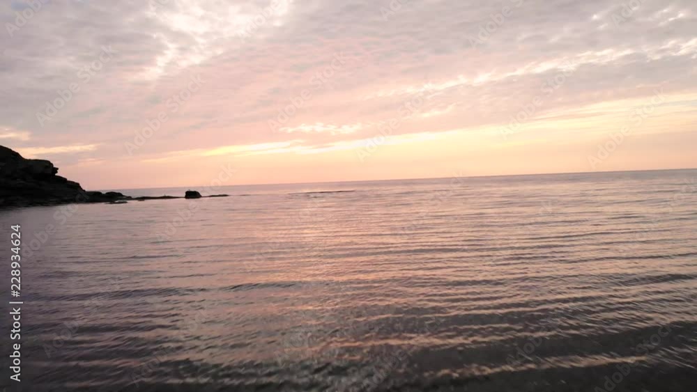 Aerial Shot Over Calm Ocean Cape With A Beautiful Sunset