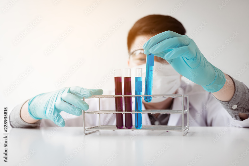 Young asian man medical researcher looking test tubes glass in laboratory. Young asian man medical researcher looking test tubes glass in laboratory.