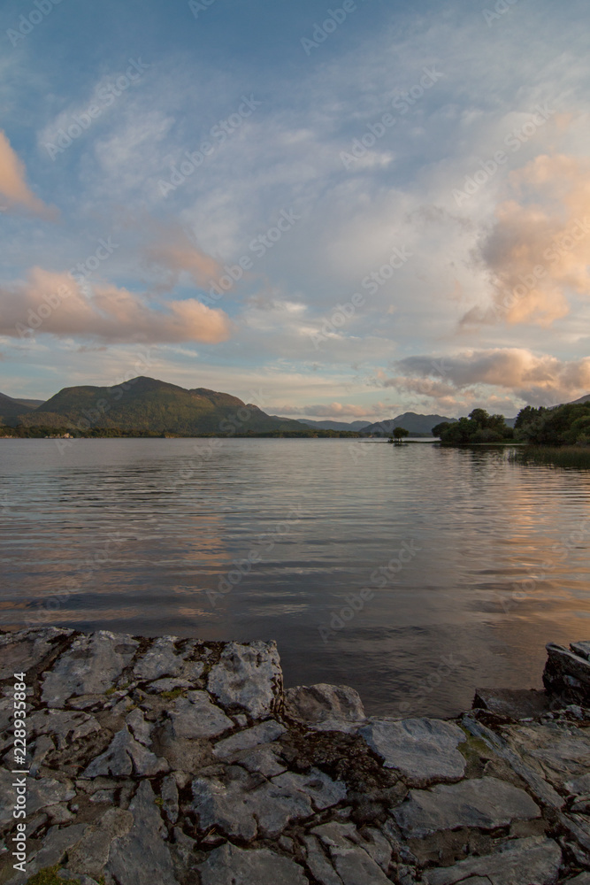 Sunset over Lough Leane (Lake Leane) as seen from the ruins of the dock of McCarthy Mor castle on the Ring of Kerry in Killarney Ireland Sunset over Lough Leane (Lake Leane) as seen from the ruins of the dock of McCarthy Mor castle on the Ring of Kerry in Killarney Ireland