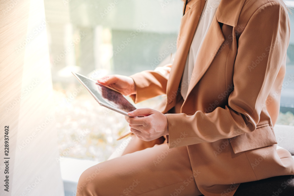 Business Woman with brown suit cloth holding digital tablet
