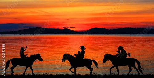 silhouette Cowboy riding a horse on sunrise