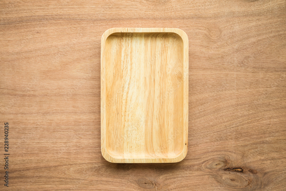 Top view of unused brand new brown handmade wooden dish plate on wooden table background Top view of unused brand new brown handmade wooden dish plate on wooden table background