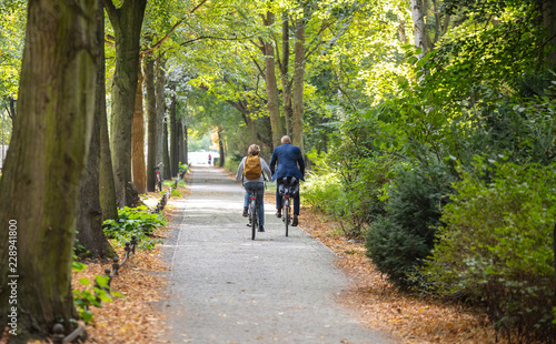 Fototapeta Naklejka Na Ścianę i Meble -  Tiergarten city park in Berlin, Germany. View of a mature couple riding bicycles