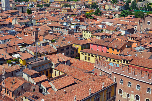 On the red tiled roofs of a small no name Italian city there are many satellite TV antennas and roof windows