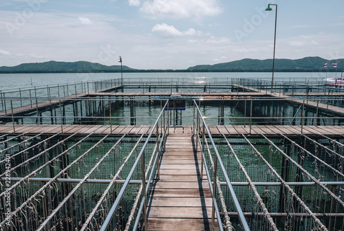 Wooden pedestrian path over sea surface with beautiful view of Ao Khung Kraben bay at Sea Fish Farming Demonstration Unit, Royal Project, Ta Mai District, Chanthaburi. photo