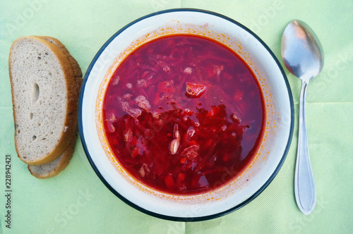 Hot red fat  rustic soup in meat broth from vegetables and beetroot- borsch and bread.