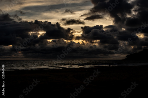 Obraz na płótnie Dramatic clouds over the ocean as the sun sets and the sky turns dark, Karon Beach, Phuket Thailand. w salonie