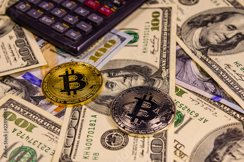 Bitcoins and scientific calculator on the one hundred dollar bills