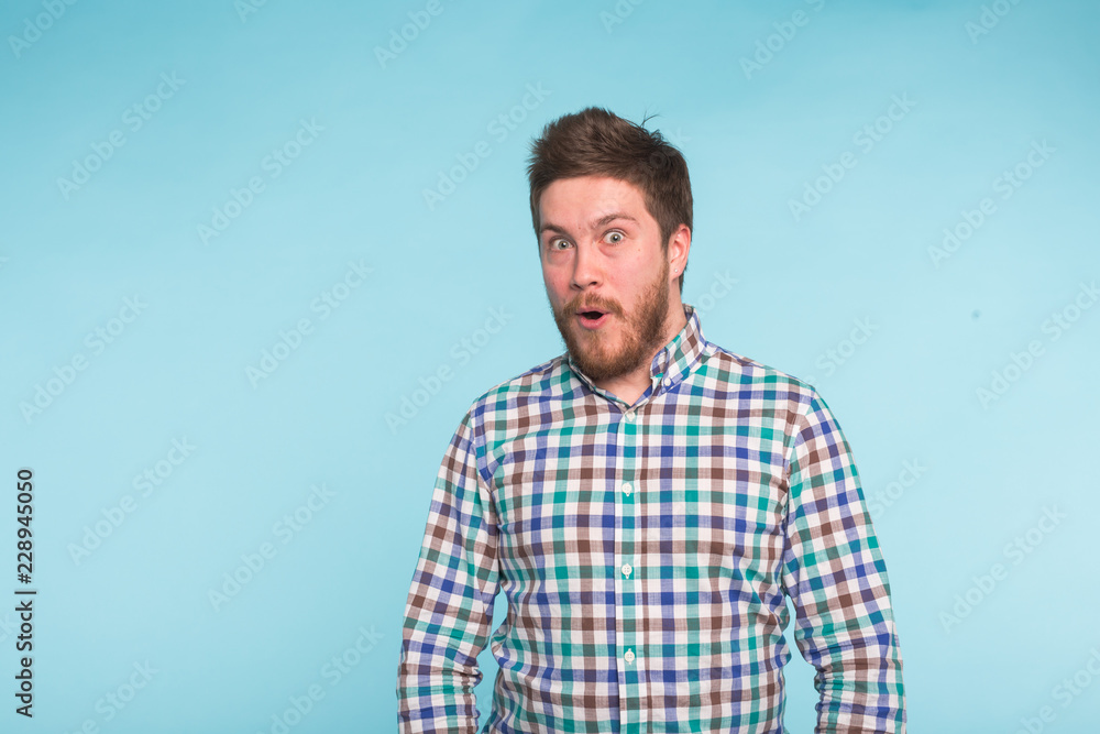 Close-up portrait of surprised bearded handsome man on blue background Close-up portrait of surprised bearded handsome man on blue background