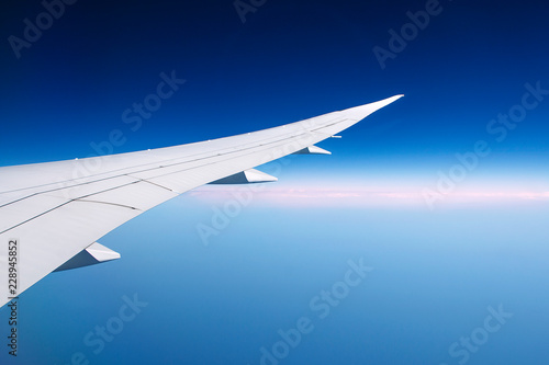 the wing of the aircraft against the blue sky