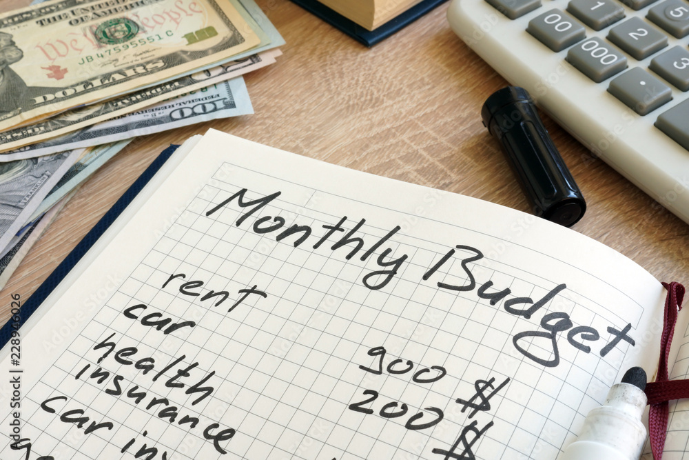 Note pad with monthly budget calculations and money. Note pad with monthly budget calculations and money.