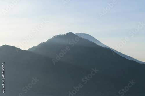 Sunrise view from Gunung Batur volcano in Bali with visible Mount Agung volcano