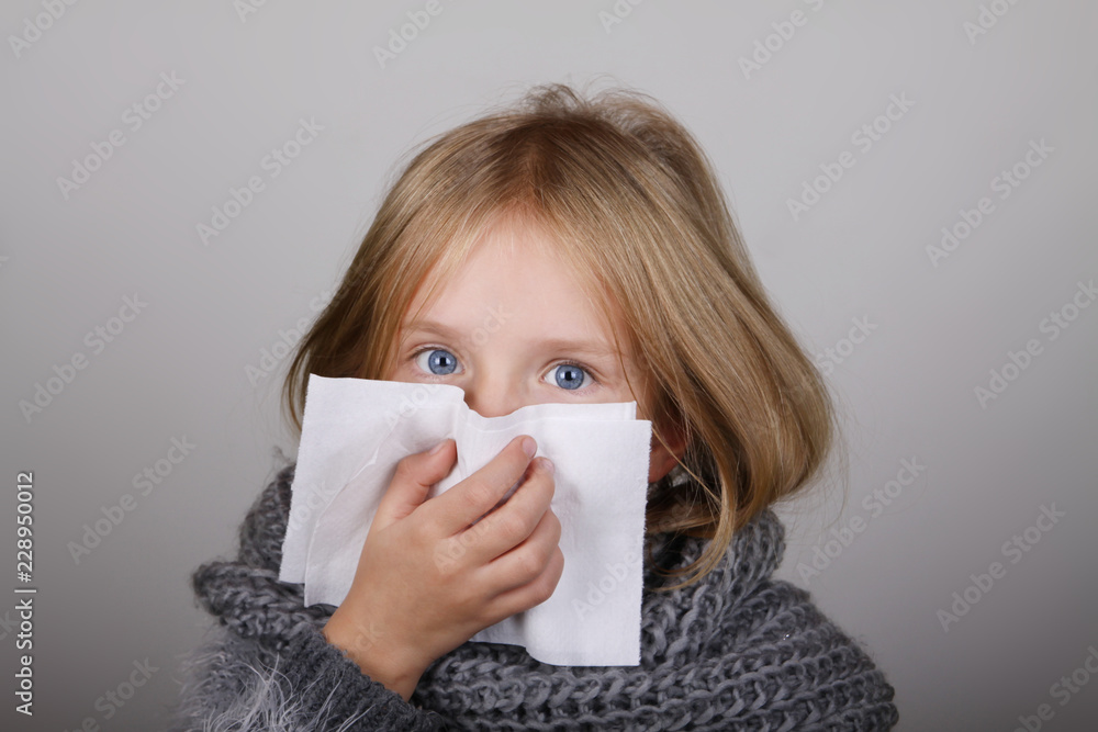cute blond hair little girl blowing her nose with paper tissue. Child winter flu allergy health care concept cute blond hair little girl blowing her nose with paper tissue. Child winter flu allergy health care concept