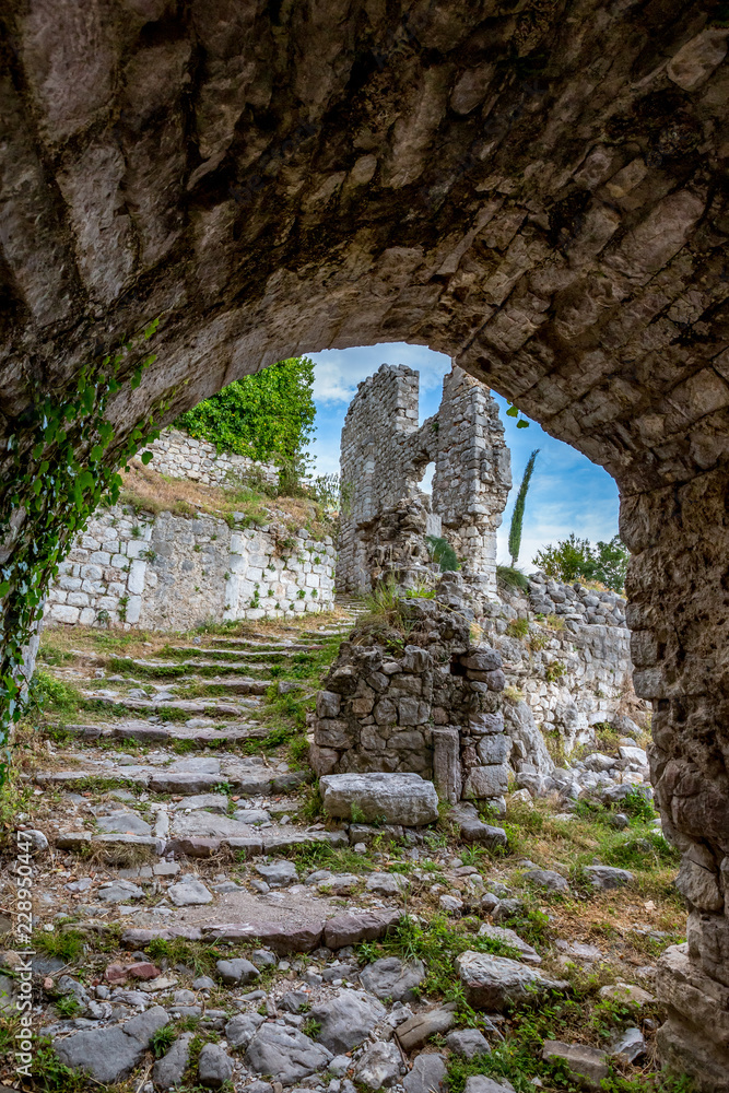 Springtime landscape of the ruins of Stari Bar ancient fortress, walking on arch way to ruined defense tower, in the medieval town of Bar in Montenegro