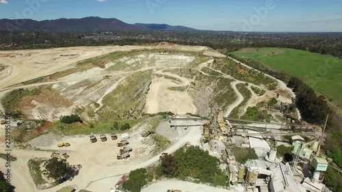 Slow aerial descend over decommissioned limestone mine factory and quarry pit