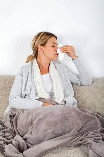 Sick woman blowing her nose