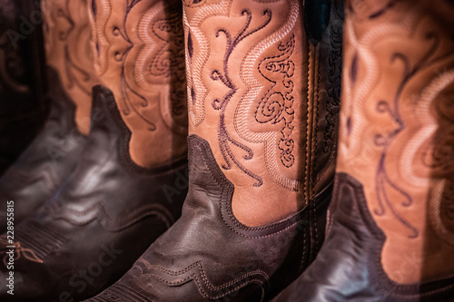 Traditional American handmade leather Cowboy boots, Western show, rodeo market and riding gear on display. National folklore, outdoor and adventure lifestyle concept.