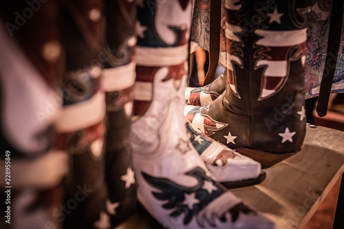 Traditional American handmade leather Cowboy boots, Western show, rodeo market and riding gear on display. National folklore, outdoor and adventure lifestyle concept.