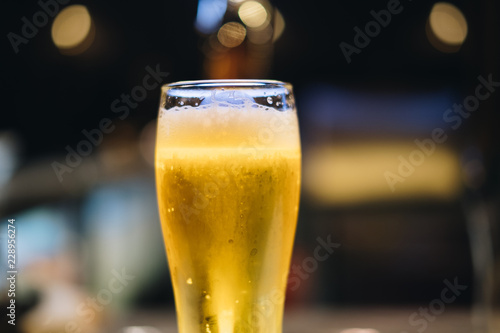 Glass of light beer with dark copy space for text