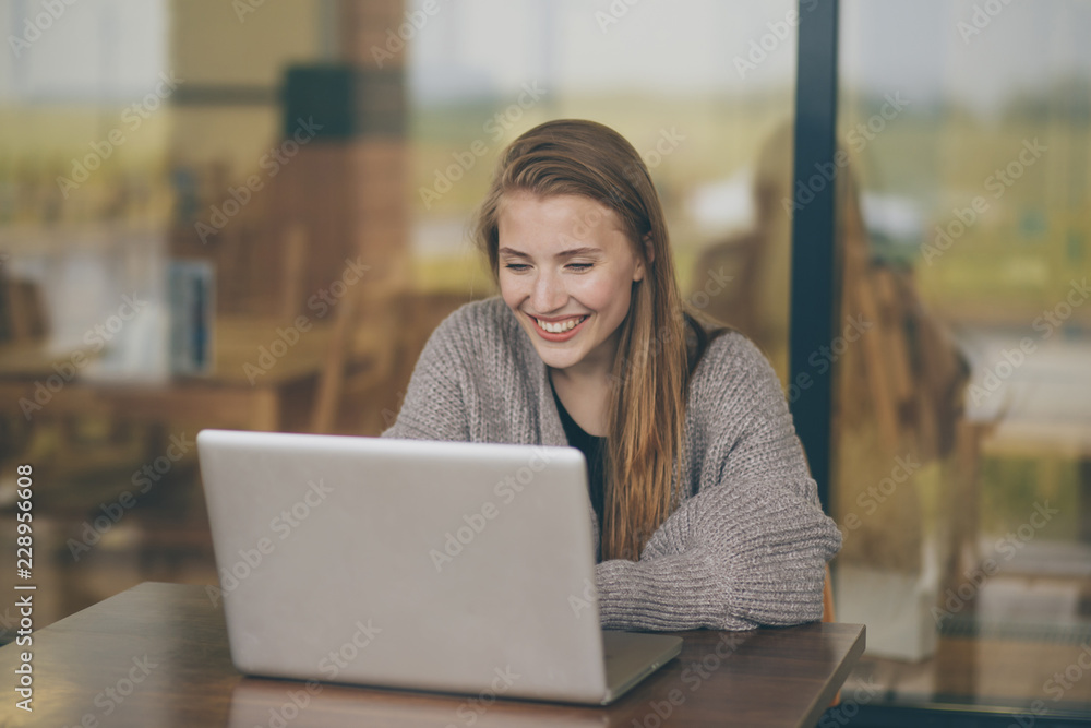 Successful female grapic designer watching tutorial about creative ideas at laptop computer during working process in office.Positive student with blonde hair reading business news on netbook Successful female grapic designer watching tutorial about creative ideas at laptop computer during working process in office.Positive student with blonde hair reading business news on netbook