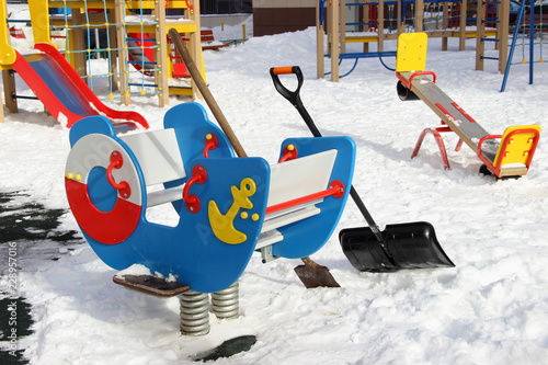 Obraz na płótnie Kids swing and snow removal equipment on modern new beautiful Playground in Mytischi in Moscow area in winter snowy day - children leisure on the outdoor w salonie
