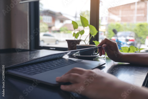 Closeup image of hands close and open a laptop computer on table after finished using it