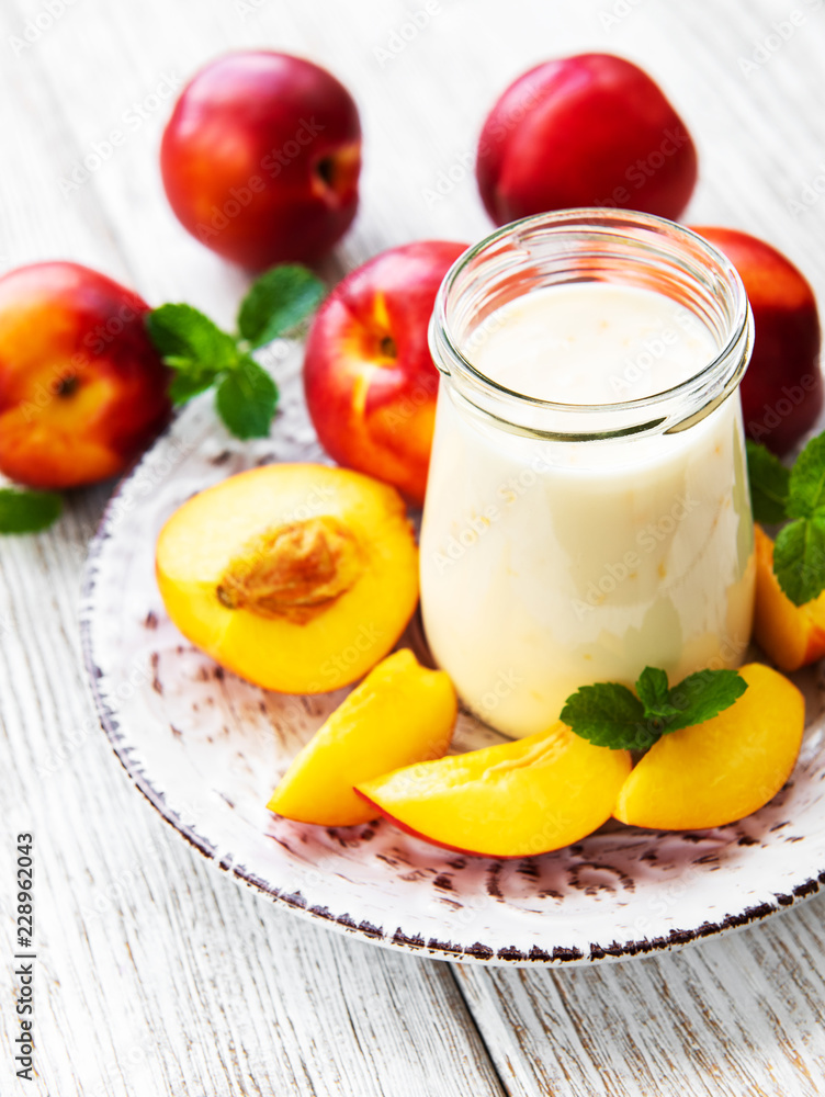 Yogurt with fresh nectarines on a white wooden table Yogurt with fresh nectarines on a white wooden table