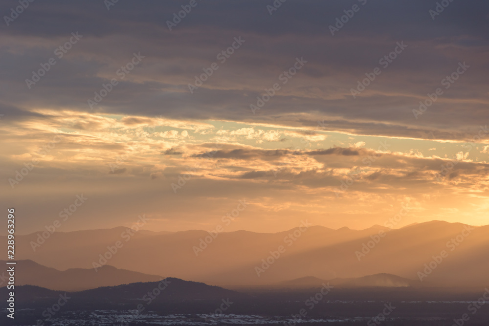 Sunrise or sunset over mountains with a city below