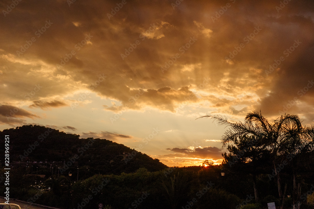 Sunset sun rays behind mountains, copy space