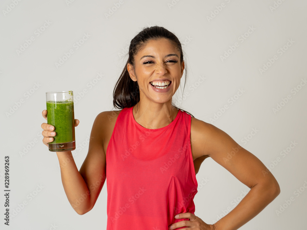 Happy beautiful fit sport woman smiling and drinking healthy fresh vegetable smoothie Happy beautiful fit sport woman smiling and drinking healthy fresh vegetable smoothie