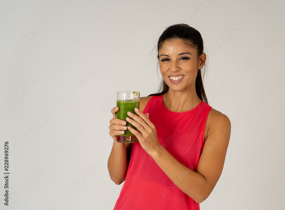 Happy beautiful fit sport woman smiling and drinking healthy fresh vegetable smoothie Happy beautiful fit sport woman smiling and drinking healthy fresh vegetable smoothie