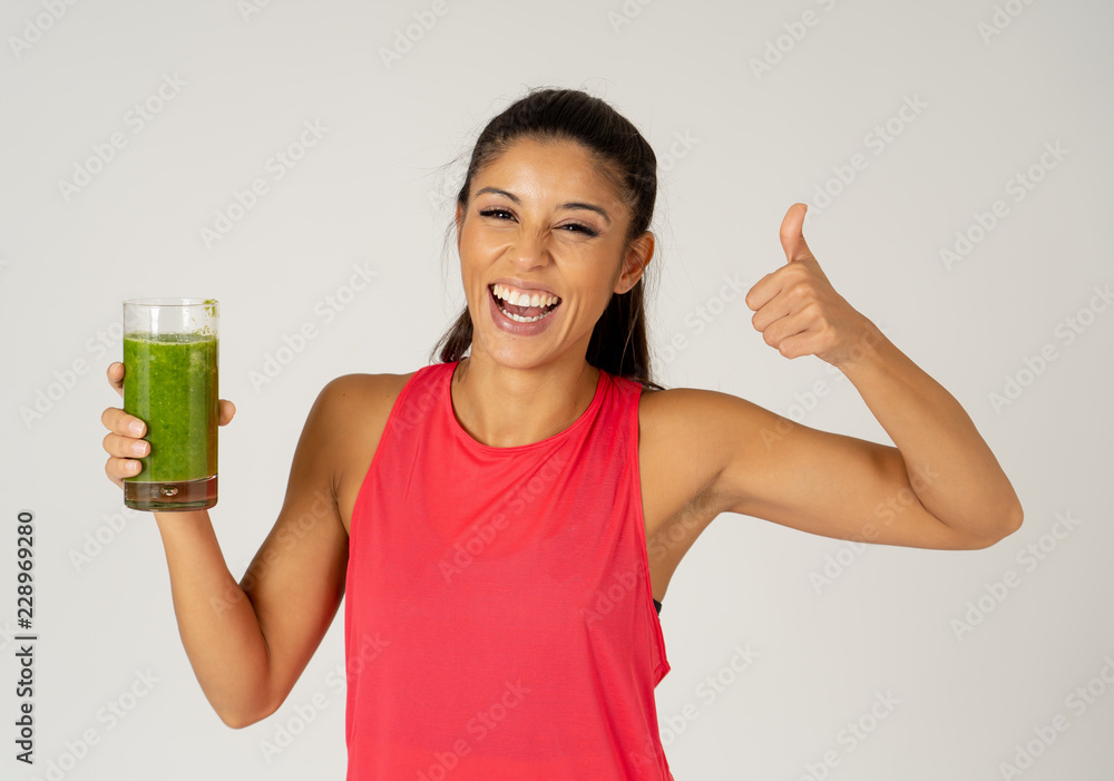 Happy beautiful fit sport woman smiling and drinking healthy fresh vegetable smoothie