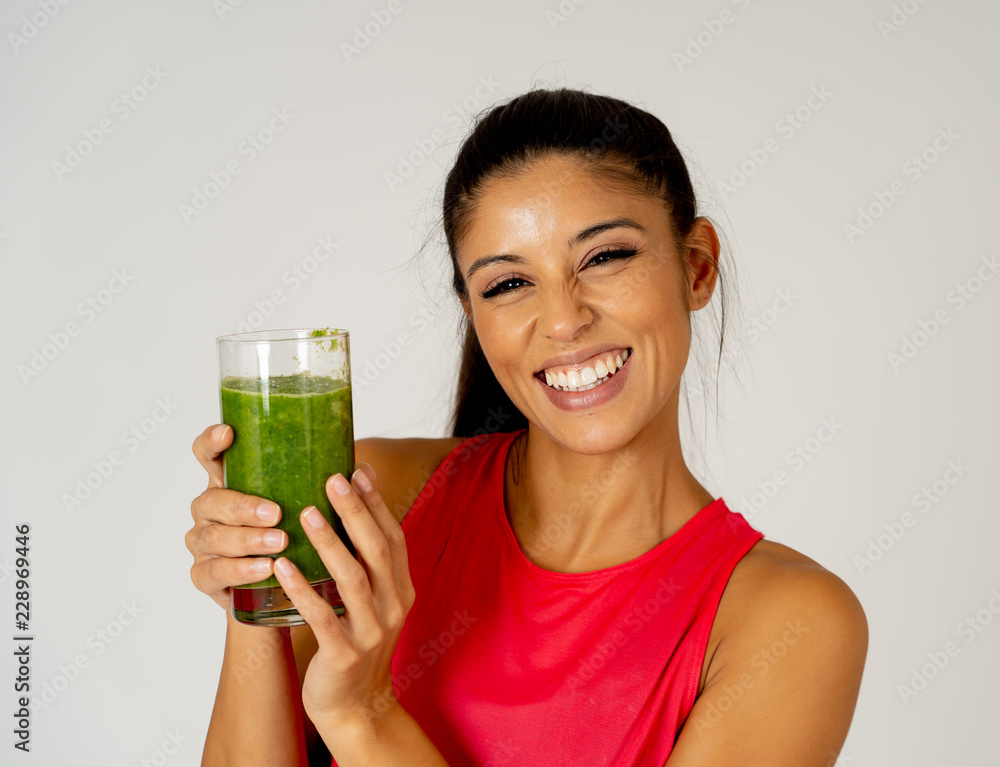 Happy beautiful fit sport woman smiling and drinking healthy fresh vegetable smoothie Happy beautiful fit sport woman smiling and drinking healthy fresh vegetable smoothie