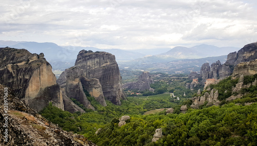 The Rousanou Monastery and The Monastery of St. Nicholas Anapausas in the background - valley famous for Greek monasteries surrounded by dark cliffs, Meteora, Kastraki, Kalambaka, Greece