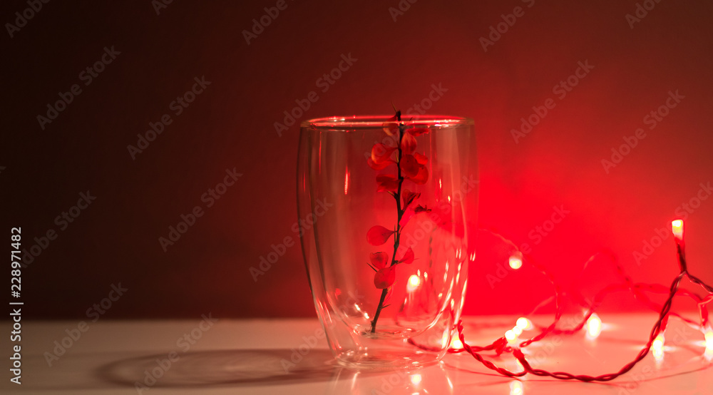 Red background. Red light bulb. A transparent glass with a twig inside. Beautiful Christmas decorations. Home interior design. Best Home decor ideas. Home Decor Red background. Red light bulb. A transparent glass with a twig inside. Beautiful Christmas decorations. Home interior design. Best Home decor ideas. Home Decor