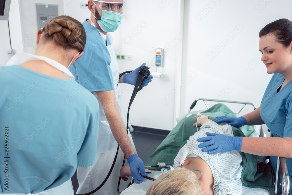 Team of doctors in hospital at endoscopy examining pictures during gastroscopy Team of doctors in hospital at endoscopy examining pictures during gastroscopy