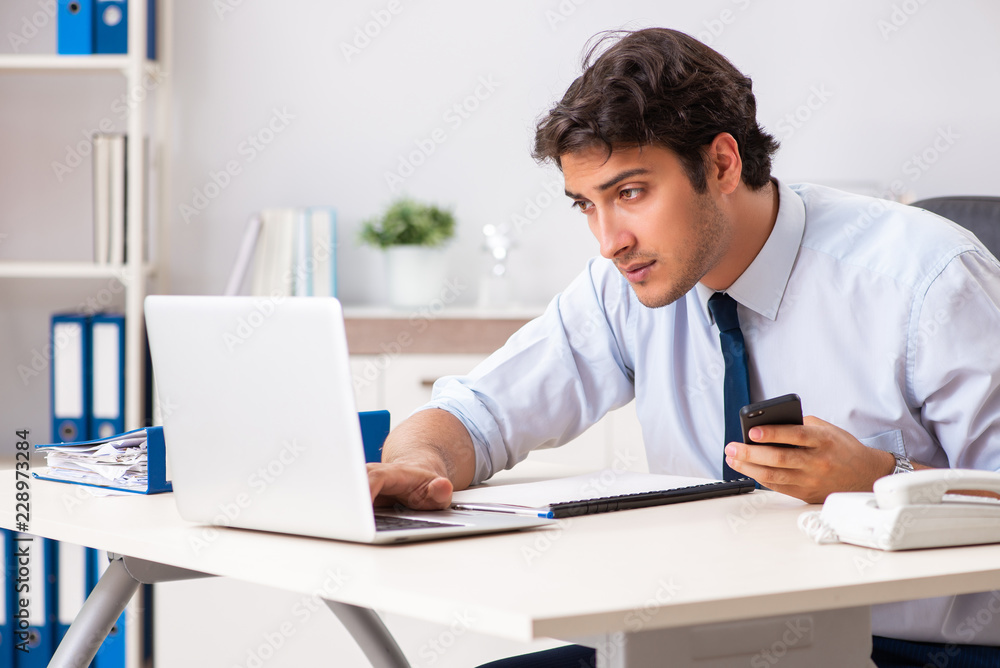 Young handsome businessman working in office Young handsome businessman working in office
