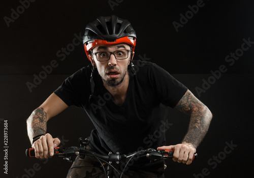 guy in the helmet and glasses on the bike to posing on a black background