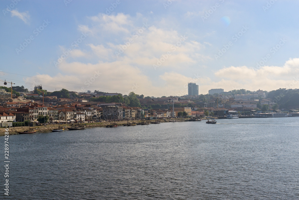 City view of Vila Nova de Gaia from the river Douro. Porto, Portugal. Boats near the shore.