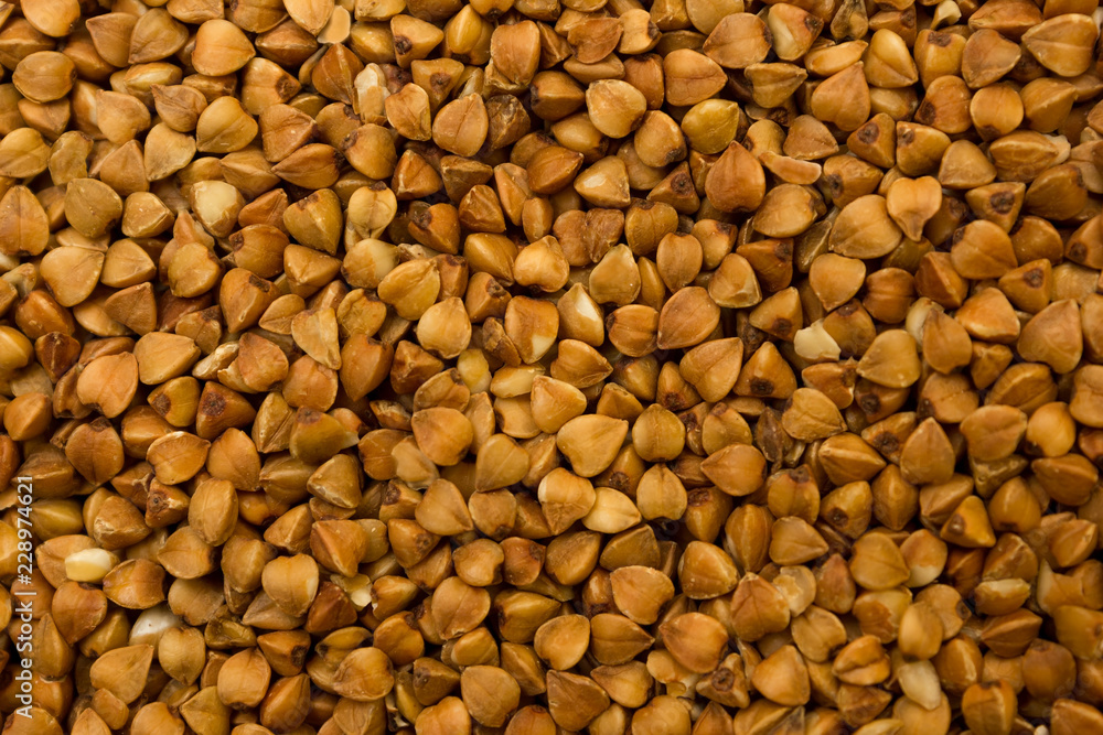 Dry buckwheat grains - brown texture Dry buckwheat grains - brown texture