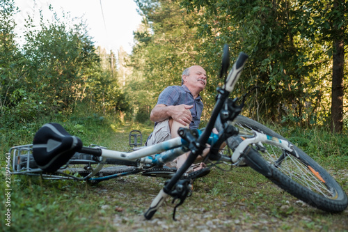 Senior man has a pain after he fell from his bike.